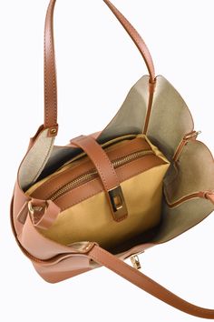 Borsa Amelie in vera pelle Spazzolata con tracolla Made in Italy e accessori color oro chiaro La parte interna è composta da un grande scomparto principale con all'interno una Pochette Estraibile con una tasca con chiusura a Zip. -Materiale esterno: Vera pelle Spazzolata -Materiale hardware: Acciaio inossidabile color oro chiaro -Materiale interno: Vera pelle di vitello lavorata -Materiale etichetta Voemièn interna: Vera pelle -Materiale manico: Vera pelle Spazzolata -Chiusura: Incastro -Confezi On-the-go Bag With Zipper Pocket And Pouch Shape, Elegant Cognac Bucket Bag For On-the-go, Office Pouch Bag With Detachable Strap, Chic Leather Backpack With Gold-tone Hardware For Everyday Use, Gold Satchel Bag With Zipper Closure, Rectangular Bucket Bag With Gold-tone Hardware For Travel, Luxury Pouch Bag With Zipper Pocket, Luxury Brown Bag With Zipper Pocket, Gold Leather Bucket Bag For Office