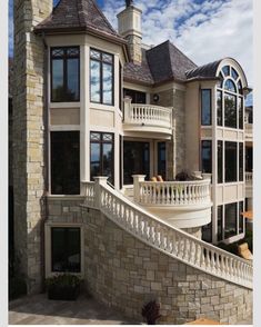 a large house with an outdoor patio and stairs leading up to the upper floor area