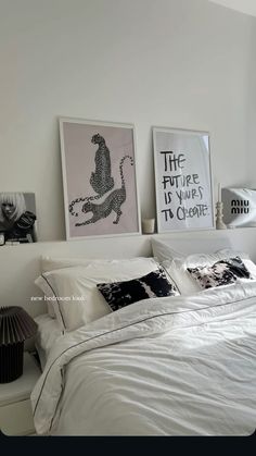 a bedroom with white walls and pictures on the wall