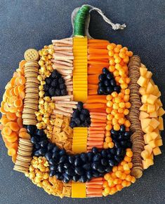 a pumpkin made out of crackers and vegetables on the ground with a string attached to it