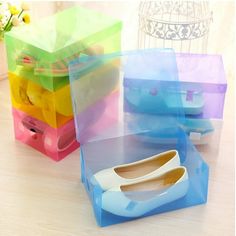 four pairs of shoes are stacked on top of each other in plastic storage boxes with handles