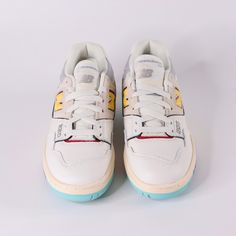 a pair of white and yellow sneakers on a white background