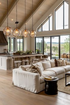 a living room filled with furniture and lots of windows next to an open floor plan