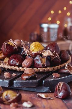 an assortment of fruits and nuts on a table with lights in the backround