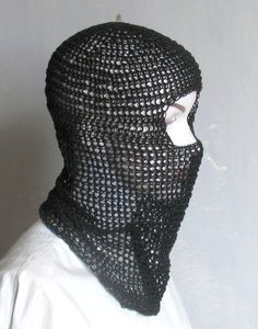 a man wearing a black knitted mask and neck gaiters with holes in the middle