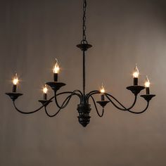 a chandelier with six lit candles hanging from it