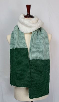 a green and white scarf on a mannequin