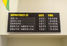 an airport departure board hanging on the wall