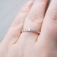 Skinny sterling silver ring that measures 2mm wide stamped with I am Worthy. Ring can come in sizes 4, 5, 6, 7, 8, 9, and 10. *Due to the process of hand stamping in each letter, the ring can stretch to be up to 1/2 size larger. Not sure of your ring size? Head over to this free printable to find your size. https://www.jewelry-secrets.com/Blog/wp-content/uploads/2015/05/Ring-Size-Chart1.pdf All Simpli Stamped jewelry comes ready to gift, packaged in a charming kraft box, tied with a coordinating Meaningful Hypoallergenic Jewelry For Promise Ring, Hypoallergenic Meaningful Jewelry, Meaningful Stamped Jewelry For Promise, Meaningful Hypoallergenic Jewelry For Promise, Meaningful Hypoallergenic Promise Jewelry, Inspirational Promise Jewelry, Hypoallergenic Meaningful Jewelry For Promises, Inspirational Hypoallergenic Everyday Jewelry, Inspirational Everyday Hypoallergenic Jewelry