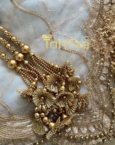 an elaborate necklace with gold beads and pearls