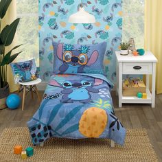 a child's bedroom with blue and yellow wallpaper, bedding and decor