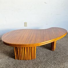 an oval wooden table sitting on top of carpet