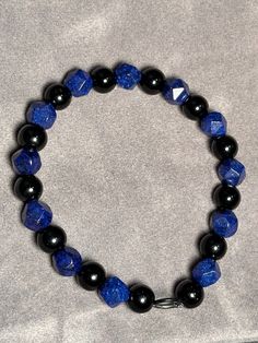 Royal blue glass beads alternating with smooth round black beads. Black And Blue Bracelet, Casual Large Blue Beads, Blue Faceted Beads Casual Style, Adjustable Blue Beaded Bracelets With Black Beads, Blue Round Beaded Bracelets With Faceted Beads, Blue Jewelry With Round Black Beads, Casual Black Gemstone Beads, Middle Island, The Color Blue