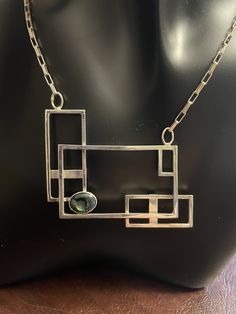 Handcrafted sterling silver necklace using square sterling wire.  Italian sterling elongated box link chain. Rectangular sterling lobster lock. Width of pendant 2 1/16 inches. Height 1 3/4 inches. bezel set opal triplet 3/4 x 1/4 inch. One of a kind creation. Modern Silver Rectangular Necklaces, Modern Silver Necklace With Rectangular Links, Silver Rectangular Necklace With Polished Finish, Modern Sterling Silver Rectangular Pendant Jewelry, Rectangular Links Jewelry With Polished Finish For Gift, Modern Rectangular Necklace With Polished Finish, Modern Sterling Silver Jewelry With Rectangular Pendant, Modern Formal Jewelry With Rectangular Stone, Modern Necklace With Rectangular Pendant And Box Chain