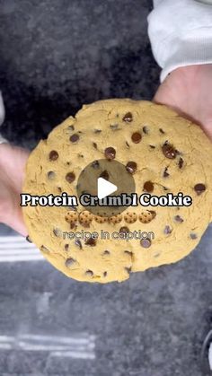 a person holding a chocolate chip cookie in their left hand with the words protein crumb cookie on it