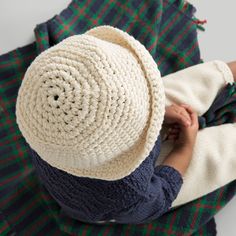 a person with a knitted hat on top of their head and one hand in the other