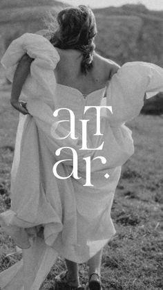 a woman in a white dress walking across a field with the words at air above her