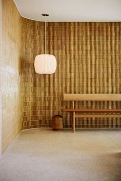 a wooden bench sitting in front of a tiled wall