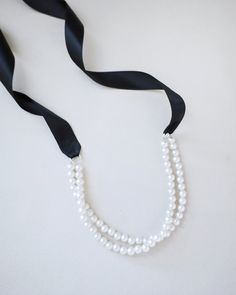 A delicate pearl necklace with a black satin ribbon closure is to add an effortless romantic and classic look to your formal or casual style. Perfect to complete your date night, wedding, bridesmaids, holiday party, and any special occasions. DETAILS:HANDMADEIMPORTED MATERIALS Black Pearl Choker As A Gift, Elegant Black Pearl Necklace, Black Choker With Pearl, Elegant Black Round Pearl Necklace, Elegant Black Single Strand Pearl Necklace, Choker Pearl, Night Wedding, Double Strand Necklace, Strand Necklace