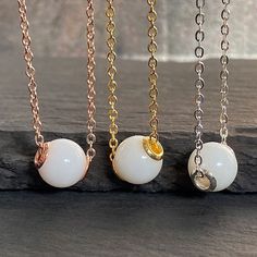 "Breastmilk pearl necklace with sterling silver cores, gold plated. Pearl effect can be added.  Our \"My Sweet Little One\" necklace transforms your breast milk into a beautiful keepsake 9 mm \"pearl\" pendant on a 20-inch flat cable chain. Add in pearl powder for a real pearlescent look. Sterling silver cores with yellow or rose gold plating options.  For all our breast milk pearl collection, please visit: https://www.etsy.com/ca/shop/KeepsakeMom?ref=seller-platform-mcnav&section_id=36089680 Fo White Charm Necklace With Pearl And Round Beads, White Pearl Charm Necklace With Round Beads, Dainty White Round Pendant Jewelry, White Pearl Charm Pendant Necklace, Minimalist White Jewelry With Pearl Charm, White Round Pearl Necklace In Minimalist Style, White Pendant Necklace With Pearl Charm, Minimalist White Sterling Silver Necklace, Minimalist White Round Pearl Necklace