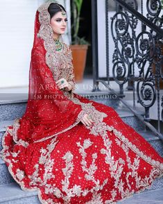 a woman in a red bridal gown sitting on steps