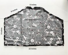 a black and white flowered apron hanging on the wall