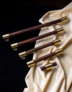 four brass and wood canes sitting on top of a white cloth