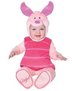 a baby in a pig costume sitting on the ground with her hands out and smiling