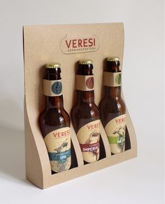 three bottles of beer sitting in a cardboard box with labels on them that say veresi