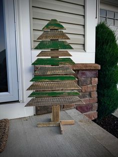 a wooden christmas tree sitting on top of a porch