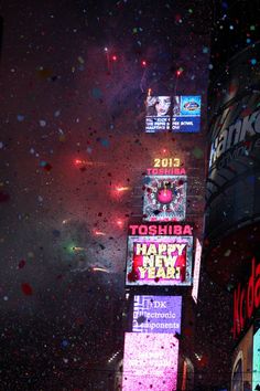 fireworks and confetti are lit up in the night sky at times square, new york city