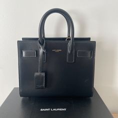 Saint Laurent Handbag Black Never Worn!! Have Dust Bag And Box ! Light Luxury Everyday Rectangular Bag, Rectangular Bags With Branded Hardware, Designer Everyday Luxury Box Bag With Top Handle, Designer Box Bag With Top Handle For Everyday Luxury, High-end Square Bags With Branded Hardware, High-end Black Rectangular Bags, Rectangular Shopping Bag With Branded Hardware, Rectangular Shopping Bags With Branded Hardware, High-end Black Box Bag For Shopping