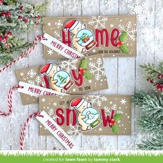 three handmade christmas tags with the words merry christmas and santa clause on them, sitting next to evergreen branches