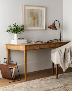 a desk with a chair, lamp and pictures on the wall