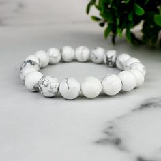 Imagine a piece of jewelry that not only adds a touch of elegance but also tells a story of mystical adventures and bohemian wanderlust. Our Enchanted White Howlite Boho Bead Bracelet is just that! Inspired by the calming aura of White Howlite and the free-spirited essence of bohemian fashion, this bracelet is crafted to perfection. Origin Story: The idea for this bracelet came from a serene walk through a mystical forest, where the shimmering white stones seemed to whisper tales of ancient wisd White Spiritual Beaded Bracelets For Friendship, Spiritual White Beaded Bracelets For Friendship, White Minimalist Bracelet Jewelry, Minimalist White Bracelet Jewelry, Adjustable Howlite Bracelet With 8mm Beads, Adjustable White Spiritual Bracelets, White Hand-strung Bangle Jewelry, Adjustable White Bracelets For Jewelry Making, Howlite Bracelets With Round Beads As Gift