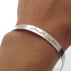 Custom Arabic engraved bangle bracelet for women. Handcrafted in Sterling silver, this distinctive, minimalist style design will spell your message with the engraving of your choice.  The band can be both sides customized with your message. It may turn into a fine Muslim gift when engraved with a message in Arabic language.  But I can make the personalization in any language you wish. You design the main bracelet part - the message that will make it really unique! Features: - Engraving up to 50 characters - Gift for her - Quran Bracelet - Personalized Gift - Arabic jewelry - High quality - Shiny finish - Gift wrapping Details: 925 Sterling Silver  Just write me any words, names or dates you want to get engraved! Size: Adjustable  Width 1/5 inch (6mm)  Circumference 6.2 inch  (Europe Size - Inspirational Engraved Name Bracelet, Engraved Bangle Bracelet For Personalized Gift, Minimalist Engraved Name Bangle Bracelet, Minimalist Engraved Bracelet For Promise, Minimalist Engraved Promise Bracelet, Inspirational Engraved Bangle Bracelets, Minimalist Adjustable Engraved Bangle, Inspirational Engraved Bangle Bracelet, Adjustable Minimalist Engraved Bangle