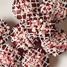 red and white sprinkled cookies are arranged on a plate, ready to be eaten