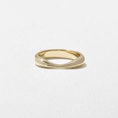 a gold wedding ring on a white background