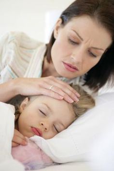 a woman and child laying in bed with their hands on each other's head