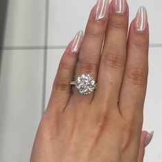 a close up of a person's hand with a diamond ring on their finger