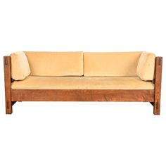 a wooden couch with two pillows on it's back and the seat upholstered