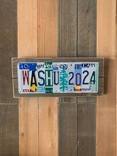 a license plate mounted to the side of a wooden wall that says washu 2012