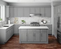 a kitchen with gray cabinets and white counter tops