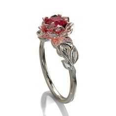 "This amazing engagement ring positively radiates beauty and strength. With its vibrant colors and lovely floral design, it's sure to be a conversation starter. Choose this piece of fine jewelry for someone with a unique spirit. The narrow band is created from gleaming, 14kt white gold, with a symmetrical design of white gold leaves at the top, which surround a beautiful lotus flower crafted from warm rose gold. At the very center sits a glistening, vivid ruby. ★See A Video Of This Amazing Ring Luxury Ruby Flower Ring Fine Jewelry, Luxury Flower-shaped Ruby Ring In Fine Jewelry Style, Elegant Flower-shaped Ruby Promise Ring, Elegant Flower Shaped Ruby Promise Ring, Red Flower-shaped Ring For Wedding, Red Flower Shaped Wedding Ring, Wedding Red Flower-shaped Ring, Wedding Red Flower Shaped Ring, Elegant Red Flower Promise Ring