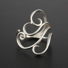 Graceful silver spirals wrap around your finger with this adjustable silver ring. Like a swirling cloud or a breath of wind, this lightweight ring is eye-catching and fun to wear. Materials: Sterling silver Fits Sizes: 5-10 Include your size as a note at checkout to have it pre-adjusted to the perfect fit for you. You may be able to (carefully!) adjust it yourself, but it would be best to have a jeweler help you! For larger or smaller sizes - please contact me about a custom order. This ring is Calder Jewelry, Dating Ring, Flatware Jewelry, Wire Jewelry Rings, Metal Jewelry Making, Silver Fits, Silver Ring Designs, Silverware Jewelry, Wire Jewelry Designs