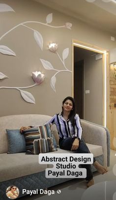 a woman sitting on top of a couch next to a wall