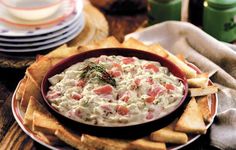 a red bowl filled with dip surrounded by crackers