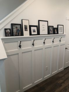 there are many pictures on the wall above the coat rack in this entryway area