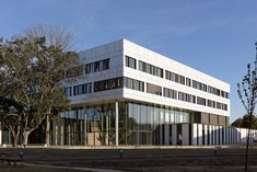 an office building with many windows and trees