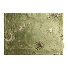 a green blanket with sun, moon and stars on the front in gold threading